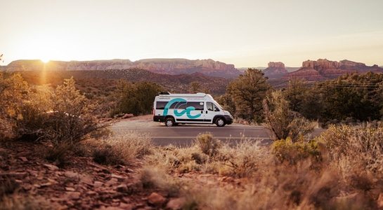 RV standing at a roadside in USA with sundown in the background