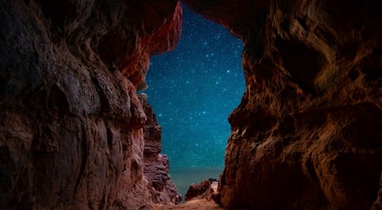 star-filled night sky framed by red canyon walls near Sedona, a magical stop on an Arizona road trip itinerary