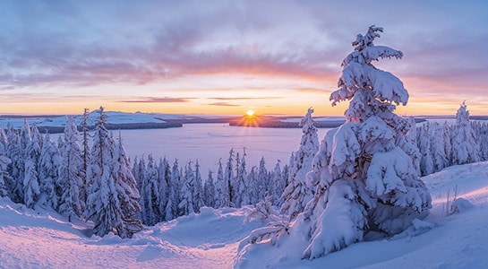Snowy landscape photographed in Lapland with view over the frozen lake.