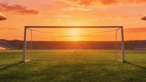 Goal in soccer stadium captured during sunset.