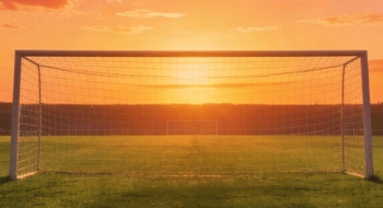Field goal in soccer stadium captured during sunset.