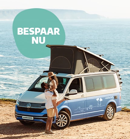 couple in front of a campervan on the beach with sea in background in summer