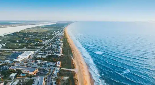 Aerial view of St. Augustine Beach with waves rolling along the Florida coastline.
