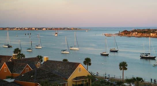 Sailboats anchored in the harbor of St. Augustine, Florida, with pastel skies at sunset along the East Coast