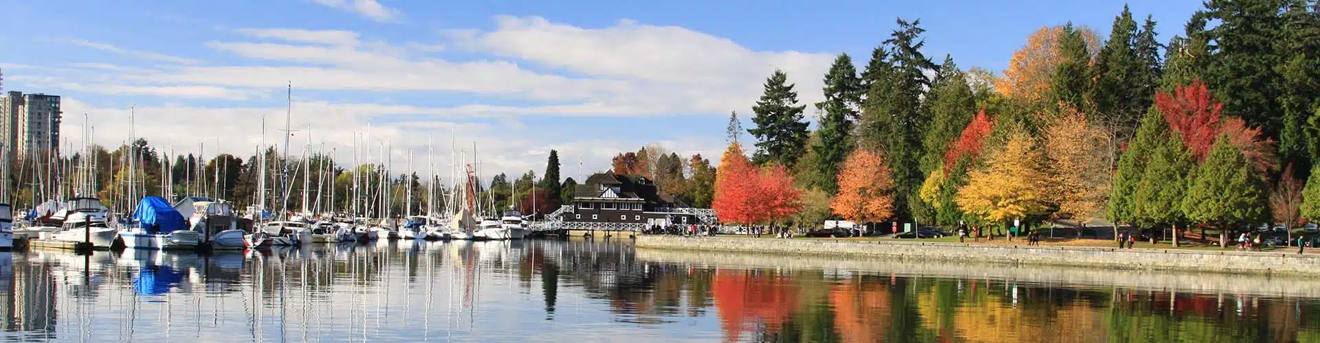 Stanley Park with colorful trees and boats in Vancouver in Canada