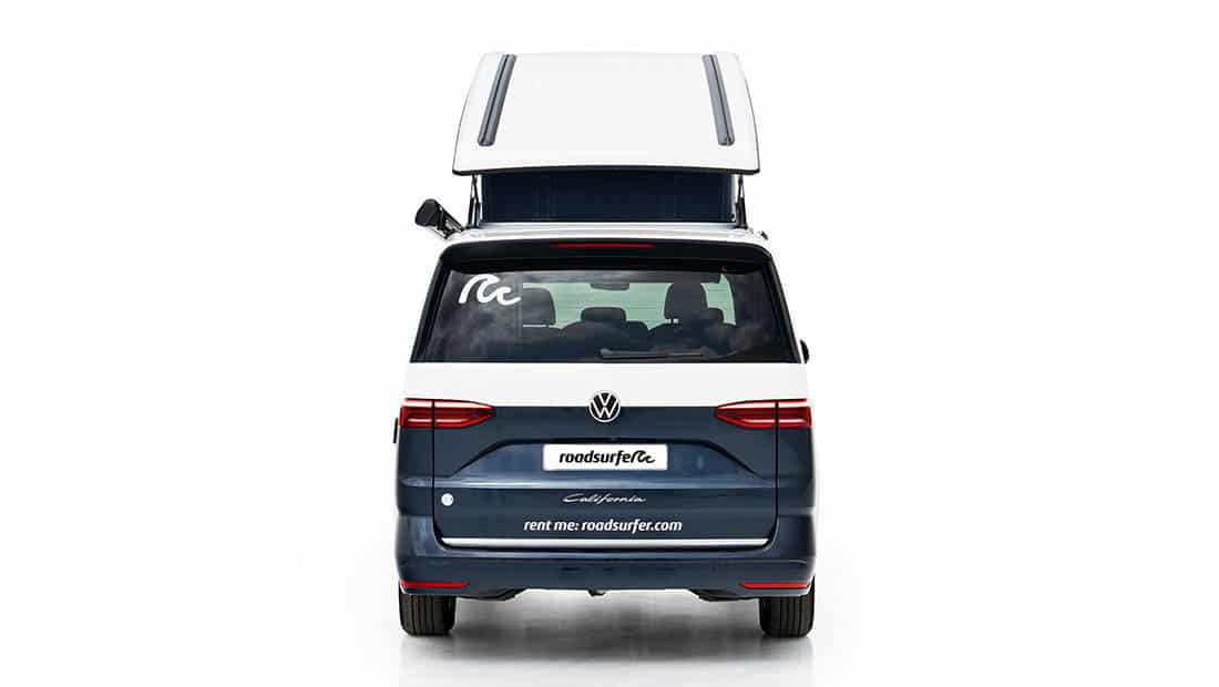 new vw california ocean as roadsurfer campervan sunrise suite in dark blue from the back with pop up roof open