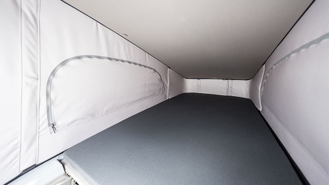roadsurfer Sunrise Suite interior view showing the roof tent to the rear