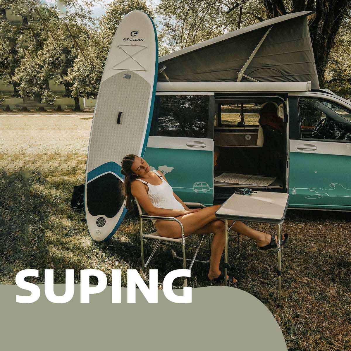 Suping: Campervan mit SUP Board angelehnt und entspannte Frau in einem Stuhl im Vordergrund