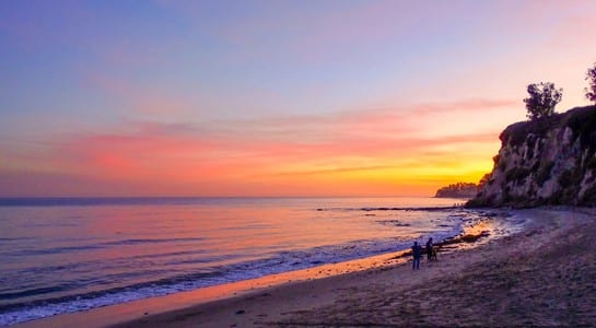 Sunset view of Surfrider Beach in Malibu with cliffs and rolling waves, one of the best surfing spots in California