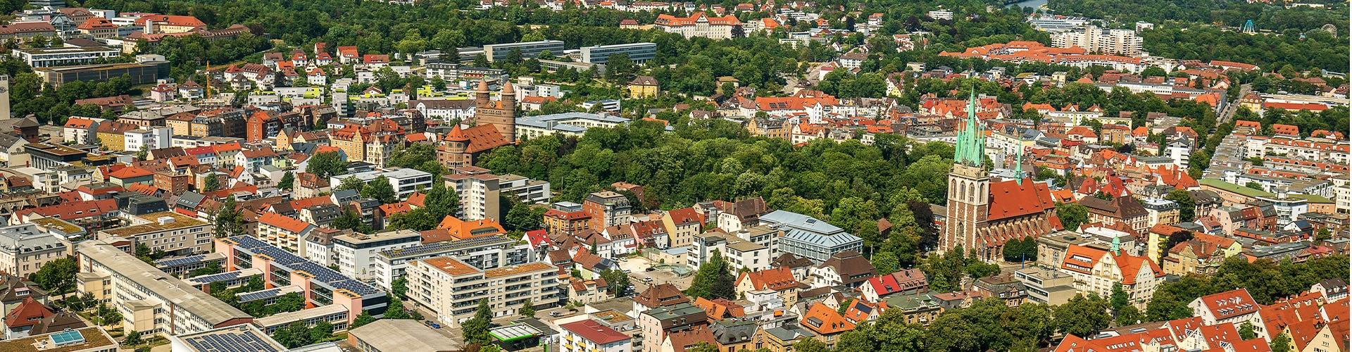 Bird view over the german city Ulm showing multiple houses and a church on a sunny day.