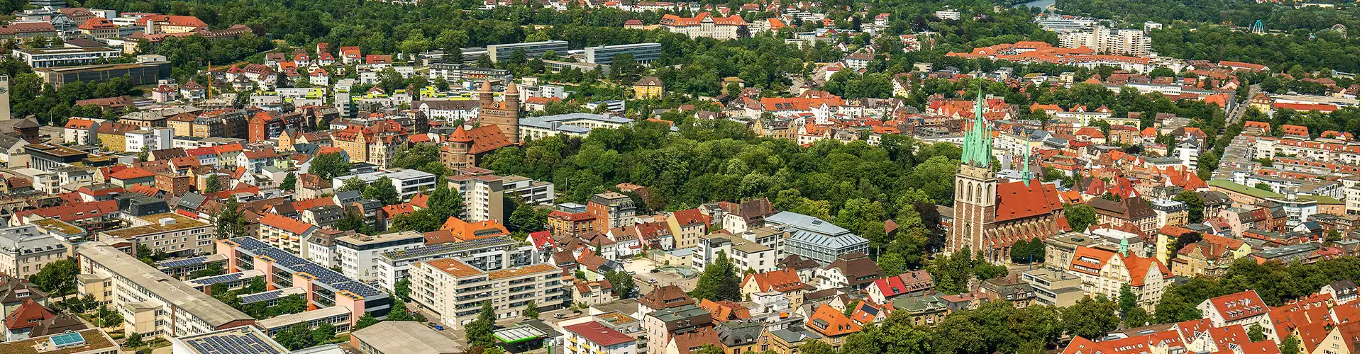 Bird view over the german city Ulm showing multiple houses and a church on a sunny day.