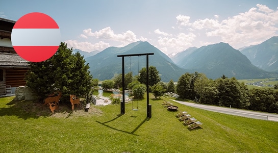 Mountain panorama in the sunshine from a campsite in Austria with a large swing