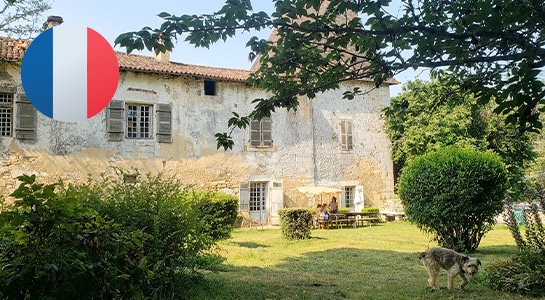 Old brick house in France with green garden and trees for camping