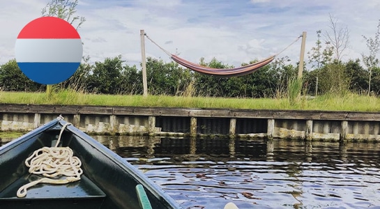 Unique riverside campsite with hammock and wooden boat in the Netherlands