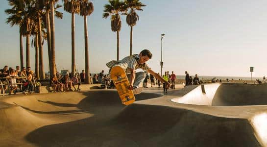 A skateboarder mid-air at Venice Beach skate park, highlighting the eclectic culture of beaches in LA.