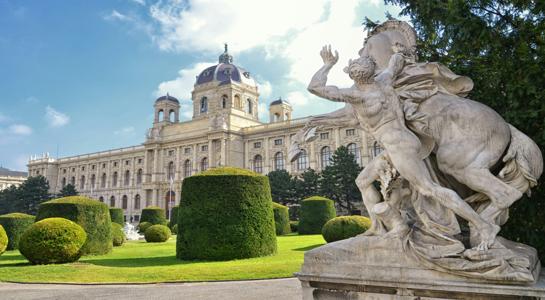 Scenic view of Vienna’s skyline and historic architecture seen from the Belvedere Palace gardens at sunset.