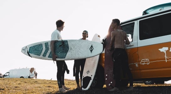 Group of surfers with surfboards preparing in the VW  camper to go to surf