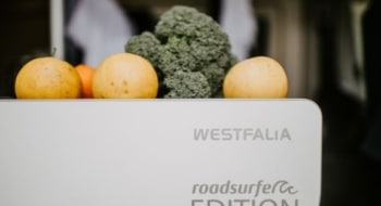 Oranges and broccoli resting on top of a Westfalia roadsurfer Edition camper van refrigerator unit