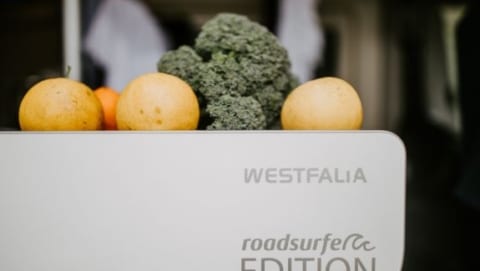 Oranges and broccoli resting on top of a Westfalia roadsurfer Edition camper van refrigerator unit