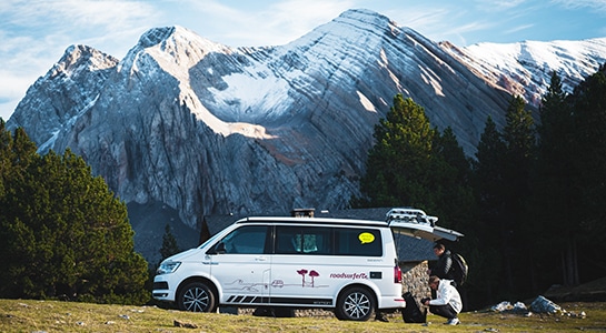 white campervan in front of mountains