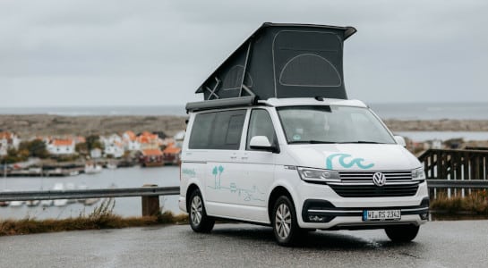 white campervan with pop up tent at a viewpoint