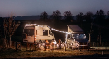 two campervans at night in winter, fairylights