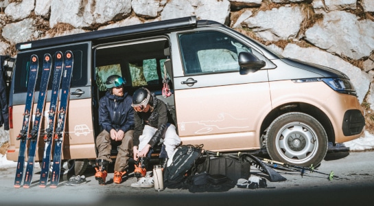 People preparing for skiing sitting in a VW California campervan