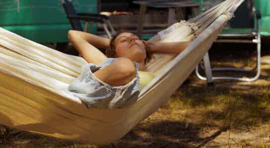 Woman laying in hammock having her eyes closed.