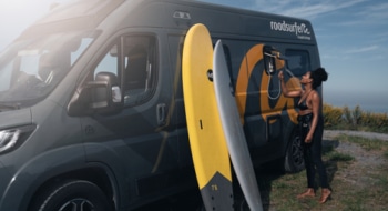 Woman using outdoor shower of a boxvan.