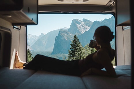 Women Drinking Coffee And Looking Out Campervan At Mountains US