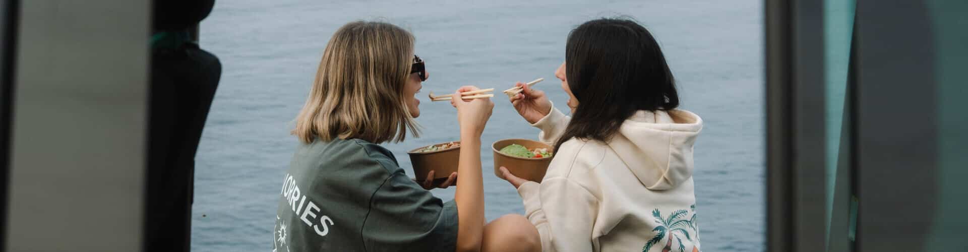 Women eating together at the seaside.