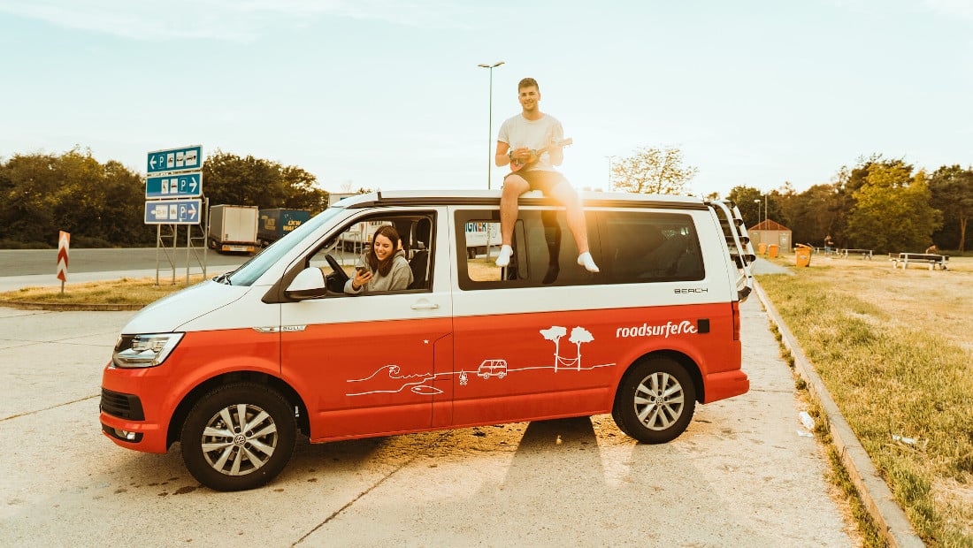 young couple in a red camper van